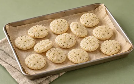 Baked jowar puffs cooling on parchment in a steel sheet pan